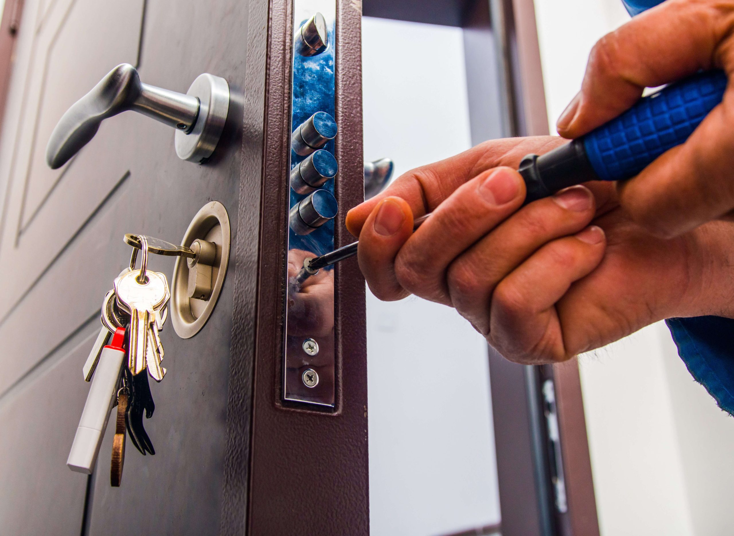 Locksmith working on door lock installation for business security.